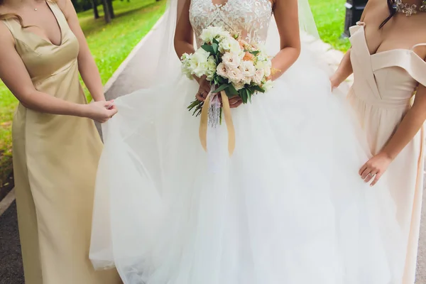 Beautiful wedding bouquet in the hands of the bride with roses. Wedding day. Bokeh. Bride. Brides bouquet. Wedding flowers. The bouquet is decorated with a brooch. — Stock Photo, Image