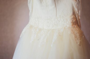 Muhteşem, beyaz lüks elbiseli gelin düğün için hazırlanıyor. Sabah hazırlıkları. Elbise giydiren kadın.