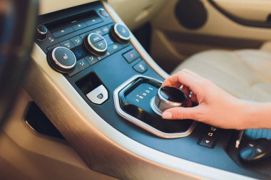 Genç kadın el arabada şanzıman vites, otomatik vites üzerinde kapatın. Araba, araba sürüş önce vites kolu vites otomatik şanzıman veya değişken hız sürücüsü tutan sürücü kadın el.
