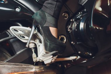 Bir motosiklet kickstart üzerinde terlik kadın ayak.