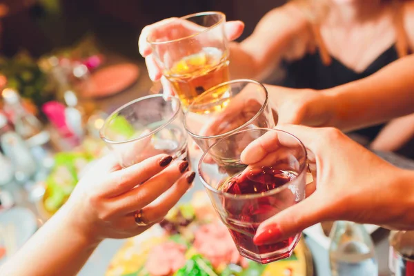 Human hands with glasses of red wine clinking them over served table. — Stock Photo, Image