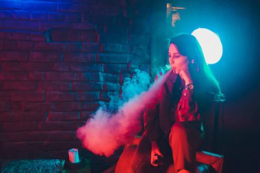 kadın odada yatakta yatan bir e-sigara içiyor. Sigara içenler kavramı Vaping.