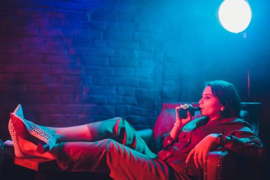 kadın odada yatakta yatan bir e-sigara içiyor. Sigara içenler kavramı Vaping.