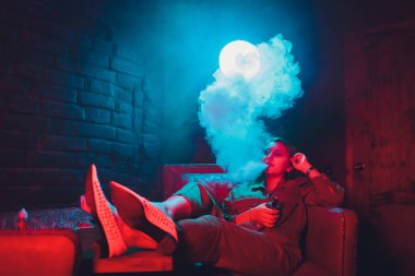 kadın odada yatakta yatan bir e-sigara içiyor. Sigara içenler kavramı Vaping.