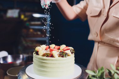 Şekerleme böğürtlen beyaz krema ile bisküvi kek ile dekore edilmiştir. Pasta ahşap bir masanın üzerinde duruyor. Ev yapımı pasta kavramı, pişirme kek.