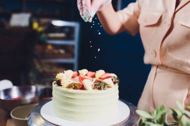 Şekerleme böğürtlen beyaz krema ile bisküvi kek ile dekore edilmiştir. Pasta ahşap bir masanın üzerinde duruyor. Ev yapımı pasta kavramı, pişirme kek.