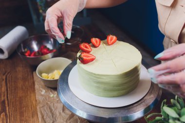 Şekerleme böğürtlen beyaz krema ile bisküvi kek ile dekore edilmiştir. Pasta ahşap bir masanın üzerinde duruyor. Ev yapımı pasta kavramı, pişirme kek.
