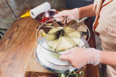 pasta şefi sünger kek katmanları üzerinde kesme. Kek üretim süreci.