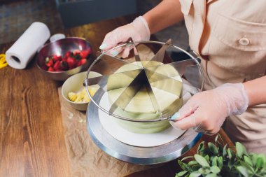 pasta şefi sünger kek katmanları üzerinde kesme. Kek üretim süreci.