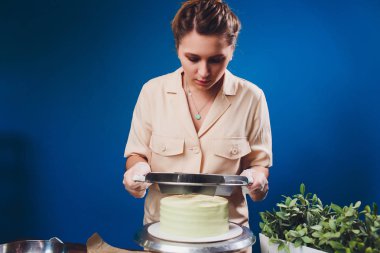 kadın elleri bir pişirme spatula kullanarak beyaz krema ile bisküvi kek yapma.