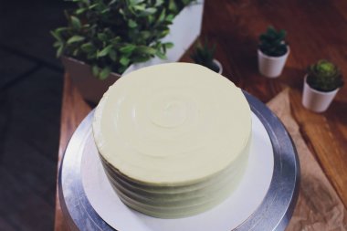 kadın elleri bir pişirme spatula kullanarak beyaz krema ile bisküvi kek yapma.