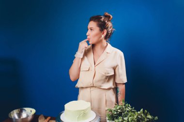 kadın elleri bir pişirme spatula kullanarak beyaz krema ile bisküvi kek yapma.