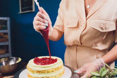 kadın elleri bir pişirme spatula kullanarak beyaz krema ile bisküvi kek yapma.