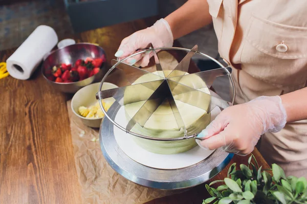 pasta şefi sünger kek katmanları üzerinde kesme. Kek üretim süreci.