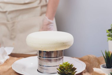 Şekerlemeci mutfakta şekerleme çantası ile bir düğün pastası yapar.