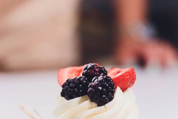 Sobremesa com bagas em um merengue com nata . — Fotografia de Stock