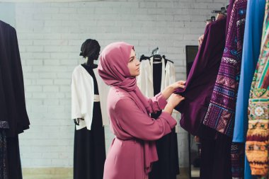 Geleneksel Müslüman giyimli Arap kadın Bir Oriental mağazasında yeni bir elbise satın alır.