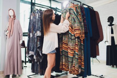 Geleneksel Müslüman giyimli Arap kadın Bir Oriental mağazasında yeni bir elbise satın alır.