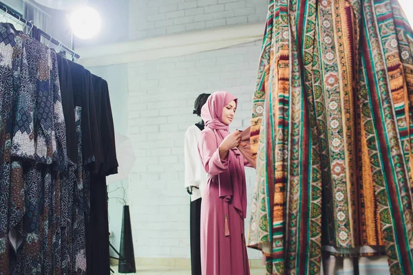 Geleneksel Müslüman giyimli Arap kadın Bir Oriental mağazasında yeni bir elbise satın alır.
