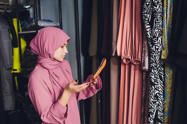 Retrato de una mujer de negocios musulmana comprueba la disponibilidad de bienes mediante el uso de la almohadilla táctil mientras está de pie en su tienda moderna, joven consultora que sostiene la tableta digital durante el trabajo en la moda — Foto de Stock