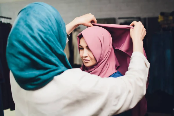 Arabische vrouw in traditionele moslim kleding koopt een nieuwe jurk in een oosterse winkel. — Stockfoto