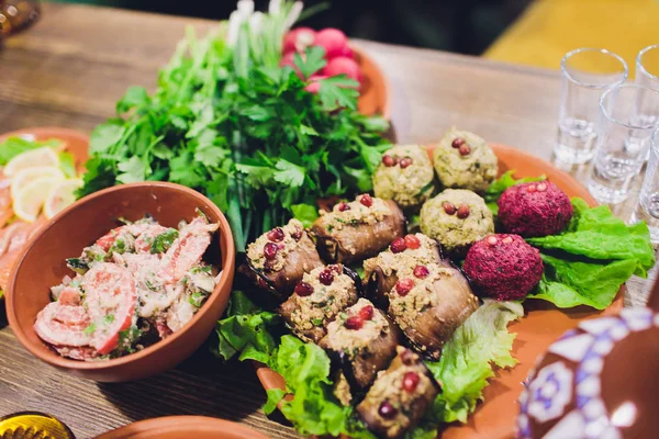 Gürcü mutfağının zengin döşenmiş sofra yemekleri, lezzetli yemekler, şarap, meyve ve kavrulmuş et çok.