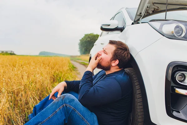 Stressad och frustrerad förare drar sitt hår medan stående på vägen bredvid trasiga bil. Road Trip problem och hjälp koncept. Rök. — Stockfoto