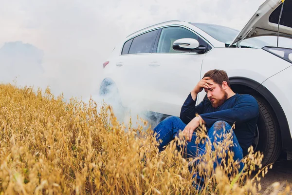 Stressad och frustrerad förare drar sitt hår medan stående på vägen bredvid trasiga bil. Road Trip problem och hjälp koncept. Rök. — Stockfoto