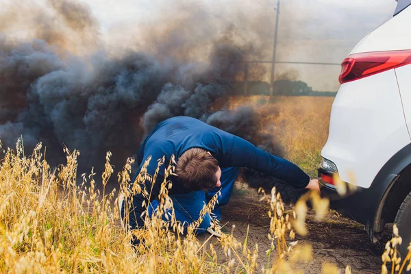 Conductor estresado y frustrado tirando de su pelo mientras está de pie en la carretera junto a un coche roto. Problemas de viaje por carretera y conceptos de asistencia. humo . — Foto de Stock