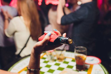 kadın odada yatakta yatan bir e-sigara içiyor. Sigara içenler kavramı Vaping.