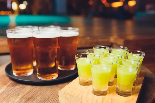 Gece kulübünde ahşap tepsiüzerinde çok renkli alkollü çekim.