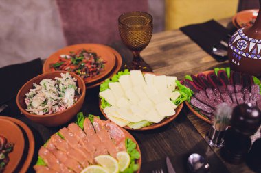 Gürcü mutfağının zengin döşenmiş sofra yemekleri, lezzetli yemekler, şarap, meyve ve kavrulmuş et çok.