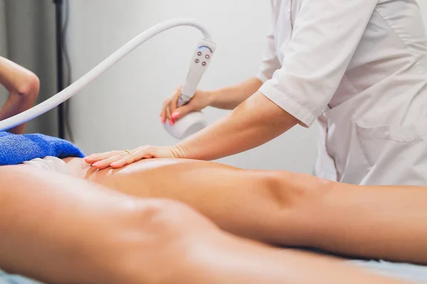Beskuren bild av kosmetolog med rollern gör skinkor starvac massage. — Stockfoto