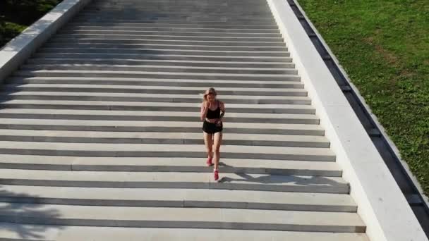 Top uitzicht van de jonge aantrekkelijke atletische vrouw snelheid op stad asfalt en training in de ochtend tijd op een zonnige zomerdag. Vrouwelijke runner training outdoor. sport concept. — Stockvideo