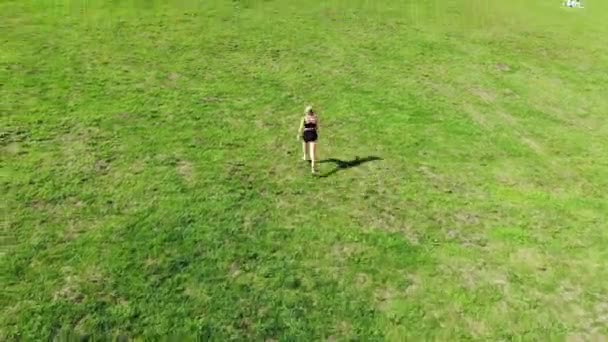 Vue de dessus de la jeune femme athlétique attrayante vitesse de course sur l'asphalte de la ville et l'entraînement dans la matinée par une journée d'été ensoleillée. Une coureuse s'entraîne en plein air. concept sportif . — Video