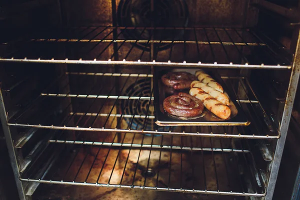 Gotowanie kiełbasy w piekarniku. Ulica Fast food. Smażone kiełbasy. — Zdjęcie stockowe