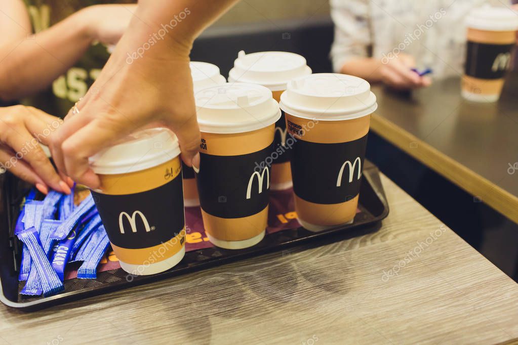 Ufa, Russia, 1 July, 2019: Paper cup of coffee with McDonalds logo on table in McDonalds restaurant