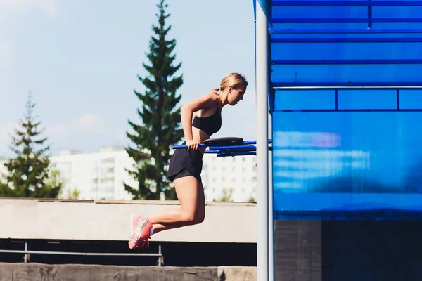 Bazı tricep dips bir parkta bankta yapıyor bir kadın atlet profil görünümü. — Stok fotoğraf
