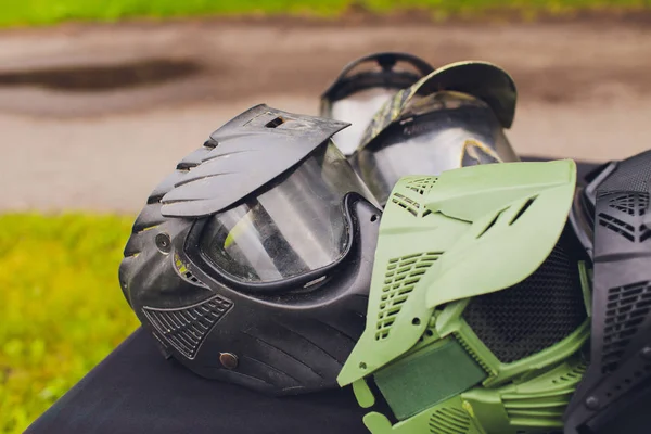 Capacete de paintball preto e verde. Máscara, um capacete para um jogo em um paintball . — Fotografia de Stock