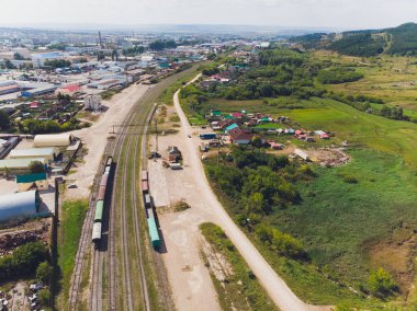 Kargo trenleri yakın plan. Tren istasyonundaki renkli yük trenlerinin hava manzarası. Demiryolunda malları olan vagonlar. Ağır endüstri. Trenli endüstriyel kavramsal sahne. Uçan İHA 'nın üst görüntüsü