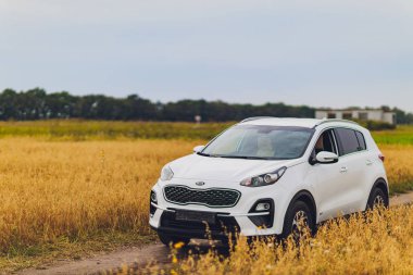 Ufa, Rusya, 1 Temmuz 2019: araba Kia Sportage 2.0 Crdi awd veya 4x4, beyaz renk, yolda park edilmiş, büyük bir kayanın yanında, arka planda güzel mavi gökyüzü ile.