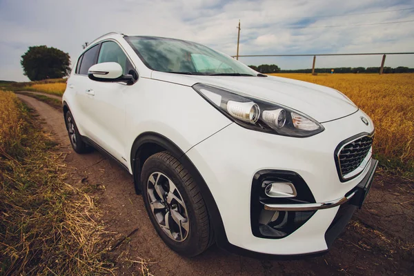 Ufa, Rusia, 1 de julio de 2019: coche Kia Sportage 2.0 CRDI awd o 4x4, de color blanco, aparcado en la carretera, junto a una gran roca, con un hermoso cielo azul en el fondo . — Foto de Stock