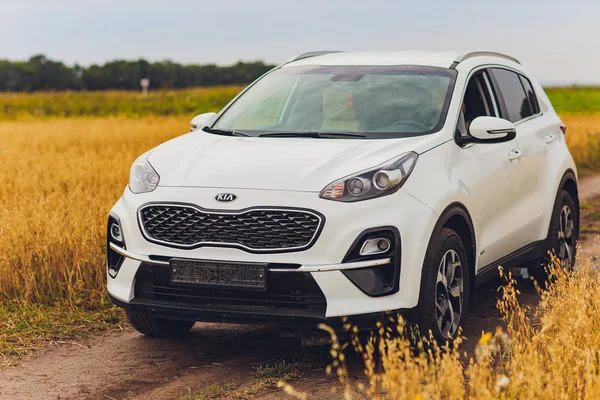 Ufa, Rusia, 1 de julio de 2019: coche Kia Sportage 2.0 CRDI awd o 4x4, de color blanco, aparcado en la carretera, junto a una gran roca, con un hermoso cielo azul en el fondo . — Foto de Stock