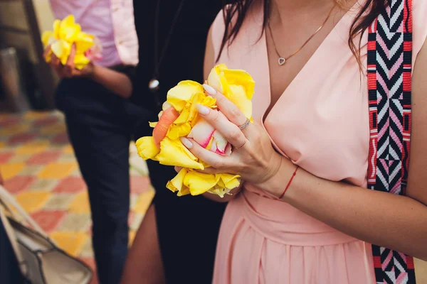 Main d'une femme pleine de pétales de rose prêts à lancer, se concentrer sur les pétales . — Photo