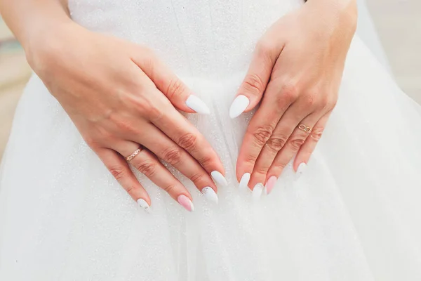 Bílé krajkové svatební šaty s dlouhými rukávy. Dámské ruce. — Stock fotografie