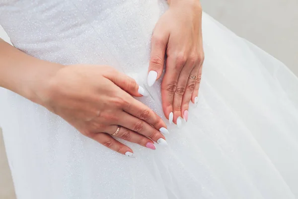 Bílé krajkové svatební šaty s dlouhými rukávy. Dámské ruce. — Stock fotografie