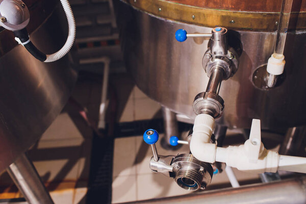 Craft beer brewing equipment in brewery Metal tanks, alcoholic drink production.