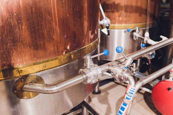 Craft beer brewing equipment in brewery Metal tanks, alcoholic drink production.