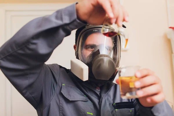 Technologist in white protective suit with hairnet and mask working in food and beverage factory. Man specialist checking bottles for beverage production. the use of iodine to check the readiness of