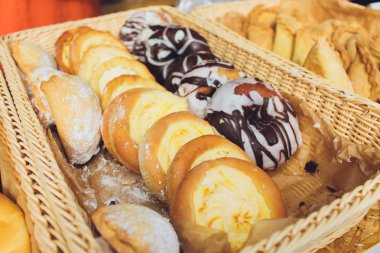 Kafe tezgahında tatlı hamur işleri çeşitleri, haşhaş tohumu, tarçın ve kuru üzüm ile ekmek rulo.